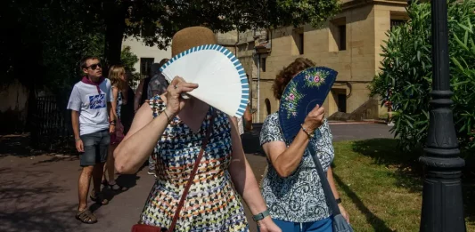 FOTOGRAFÍA. BILBAO (LAS VASCONGADAS) REINO DE ESPAÑA, 15 DE AGOSTO DE 2025. Dos mujeres se protegen del sol con sus abanicos, este viernes en Bilbao, donde han decretado alerta naranja por altas temperaturas. Efe