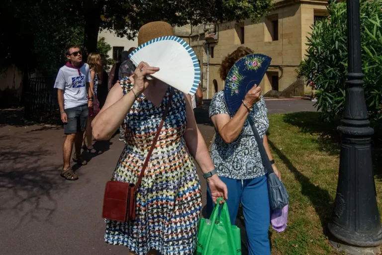 FOTOGRAFÍA. BILBAO (LAS VASCONGADAS) REINO DE ESPAÑA, 15 DE AGOSTO DE 2025. Dos mujeres se protegen del sol con sus abanicos, este viernes en Bilbao, donde han decretado alerta naranja por altas temperaturas. Efe