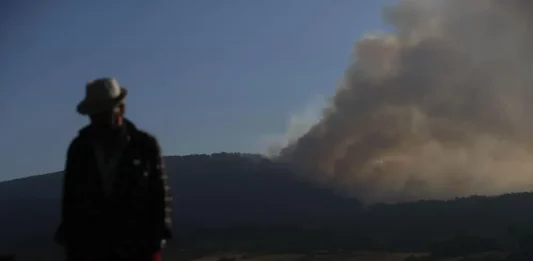 FOTOGRAFÍA. LUGO (GALICIA) REINO DE ESPAÑA, 26 DE AGOSTO DE 2025. Un hombre camina con la columna de humo de fondo desde el Mirador da Capela en Pobra de Brollón, Lugo. Efe