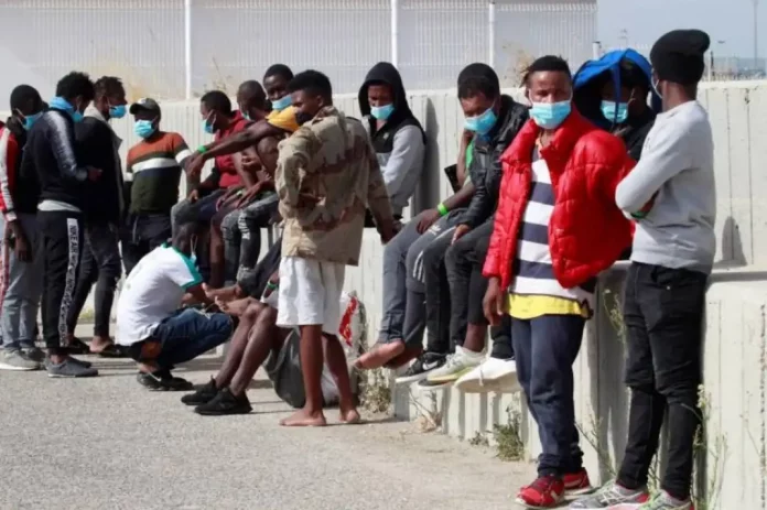 Manifiesto de Algeciras - Fronteras Seguras; una cuestión de supervivencia. Inmigración ilegal, invasión de Europa, VOX (1) FOTOGRAFÍA. ALGECIRAS (CÁDIZ) ESPAÑA, 31 DE JULIO DE 2020. Varios de los 53 inmigrantes ilegales recogidos por el barco taxi del Gobierno de España, conocido bajo nombre "Asociación Salvamento Marítimo Humanitario", en aguas del Estrecho de Gibraltar cuando intentaban alcanzar las costas españolas a bordo de una patera, esperan este viernes, 31 de julio de 2020, en el puerto deportivo del Saladillo en Algeciras (Cádiz) antes de ser trasladados por la Guardia Civil. Efe