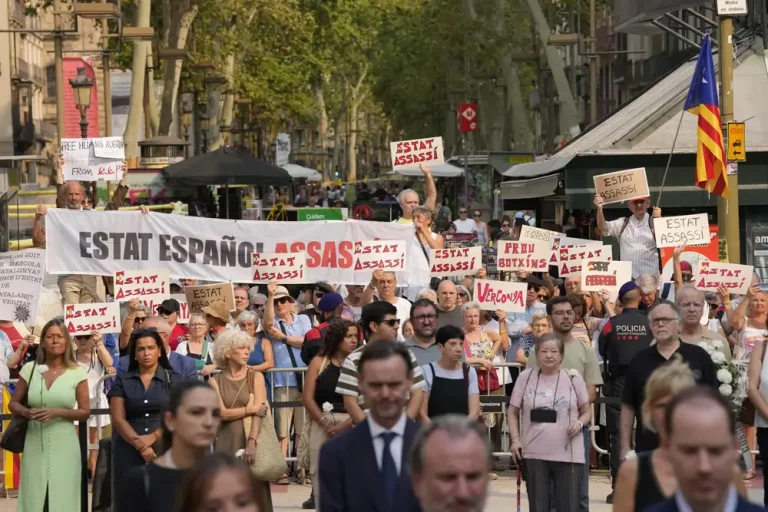 FOTOGRAFÍA. BARCELONA (CATALUÑA) REINO DE ESPAÑA, 17 DE AGOSTO DE 2025. Un grupo de manifestantes protesta durante un homenaje por el octavo aniversario del 17A este domingo, en Barcelona. Las autoridades han cedido el protagonismo a las víctimas en el acto de homenaje institucional en Barcelona por el octavo aniversario de los atentados del 17A, que causaron 16 muertos y más de un centenar de heridos, con un emotivo minuto de silencio y una ofrenda floral con claveles blancos. Efe