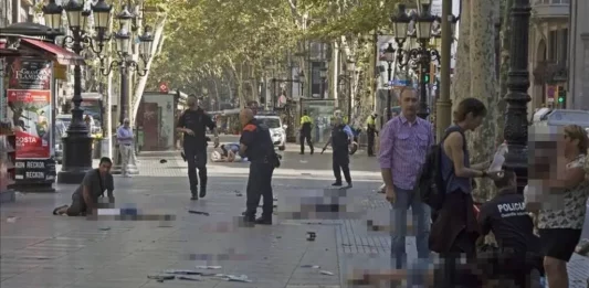 FOTOGRAFÍA. RAMBLAS DE BARCELONA (BARCELONA) CATALUÑA (ESPAÑA), 17.08.2017. La imagen de los atentados yihadistas en Ramblas de Barcelona escogida por los medios internacionales y nacionales para reflejar lo que fue el atentado terrorista de Barcelona. la imagen muestra a Harry Athwal (izquierda), un turista británico de 44 años —que durante las últimas horas se está convirtiendo en Reino Unido en el símbolo de valentía, humanidad— por ayuda a las víctimas de los atentados en Barcelona y Cambrils por su actitud con un niño agonizante en las Ramblas. Este inglés de Birmingham se encontraba en el balcón del primer piso de un restaurante de las Rambla en el momento del atentado del pasado jueves. Desde allí vio el ataque y tras pedir a sus acompañantes que no se movieran de ahí, bajo a prestar ayuda. Efe