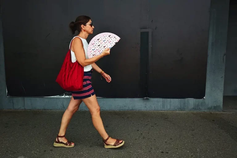 FOTOGRAFÍA. TOLEDO (REINO DE ESPAÑA), 12 DE AGOSTO DE 2025. Una persona camina con un abanico a la sombra este martes, en Toledo. Este miércoles, inestabilidad con chubascos y tormentas y descenso de temperaturas agosto 12 de 2025. Efe