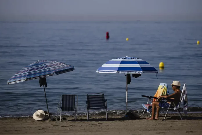 FOTOGRAFÍA. MÁLAGA 8ANDALUCÍA) REINO DE ESPAÑA, 13 DE AGOSTO DE 2025. Un hombre sentado junto al mar en la playa del Rincón de la Victoria (Málaga), este 13 de  agosto de 2025. Efe