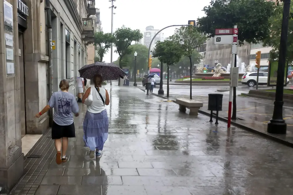 TARAGONA (CATALUÑA) REINO DE ESPAÑA, 12 DE JULIO DE 2025. dos personas protegiéndose de la lluvia en el centro de Tarragona, Comunidad Autónoma de Cataluña(Reino de España), este 12 de julio de 2025. Efe
