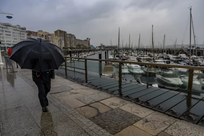 FOTOGRAFÍA. SANTANDER (CANNTABRIA) REINO DE ESPAÑA, 22 DE SEPTIEMBRE DE 2025. Un hombre se protege de la lluvia por el puerto de Santander. Efe