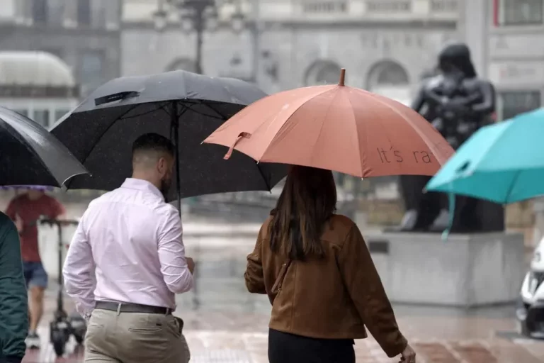 FOTOGRAFÍA. OVIEDO (REINO DE ESPAÑA), 18 de julio de 2025. Viandantes con paraguas protegiéndose de la lluvia este 18 de julio de 2025 en el centro de Oviedo. Efe