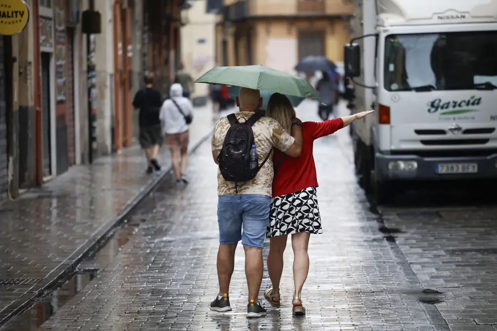 FOTOGRAFÍA. VALENCIA 8COMUNIDAD VALENCIANA) REINO DE ESPAÑA, 24 DE JULIO DE 2025. Varias personas se protegen de la lluvia en Valencia (Comunidad Valenciana) Reino de España, este 24 de julio de 2025. Efe