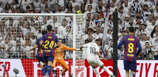FOTOGRAFÍA. MADRID (REINO DE ESPAÑA), 26 DE OCTUBRE DE 2025. El delantero francés del Real Madrid Kylian Mbappé (2d) remata para marcar gol ante el portero del FC Barcelona Wojciech Szczesny, durante el partido de la décima jornada de LaLiga EA Sports, que Real Madrid y FC Barcelona disputan en el estadio Santiago Bernabéu. Efe
