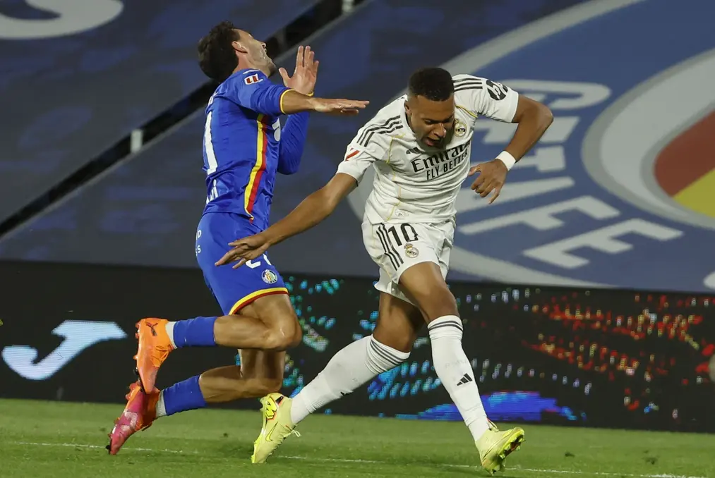 FOTOGRAFÍA. GETAFÉ (COMUNIDAD DE MADRID) REINO DE ESPAÑA, 19 DE OCTUBRE DE 2025. El defensa del Getafe Domingos Duarte pelea un balón ante el delantero del Real Madrid Kylian Mbappé (d) este domingo, durante el partido de la jornada 9 de LaLiga EA Sports que Getafe y Real Madrid disputan en el Coliseum, en Getafe (Comunidad de Madrid). Efe