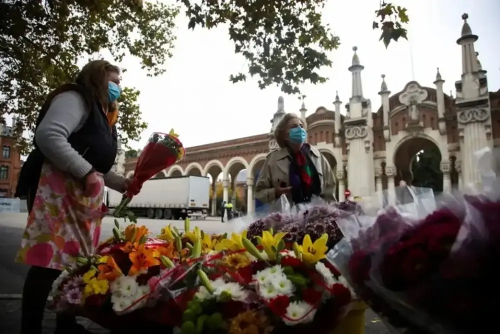 FOTOGRAFÍA. MADRID (REINO DE ESPAÑA), 30 DE OCTUBRE DE 2025. Una mujer compra flores este jueves en un puesto situado frente al cementerio de la Almudena en Madrid. Efe