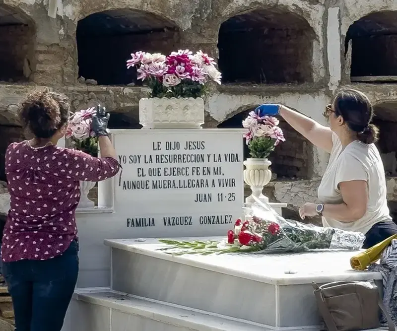 La Iglesia católica celebra la festividad del Día de Todos los Santos FOTOGRAFÍA. SEVILLA (ANDALUCÍA) REINO DE ESPAÑA, 26 DE OCTUBRE DE 2025. Dos personas limpian y colocan flores como preparativo del Día de Todos los Santos, este domingo en el cementerio de de San Fernando en Sevilla. Efe