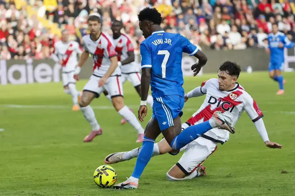 FOTOGRAFÍA. MADRID (REINO DE ESPAÑA), 09 DE NOVIEMBRE DE 2025. El defensa rumano del Rayo Vallecano Andrei Ratiu (d) pelea un balón ante el delantero brasilero del Real Madrid Vinícius Júnior (2d) durante el partido de la jornada 12 de LaLiga EA Sports que Rayo Vallecano y Real Madrid disputaron en el Estadio de Vallecas, en la capital española. Efe
