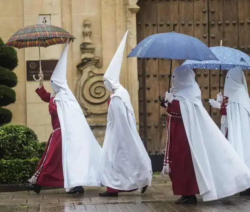 Descenso de temperatura y chubascos generalizados este viernes FOTOGRAFÍA. CÓRDOBA (ANDALUCÍA) REINO DE ESPAÑA, 25 DE MARZO DE 2024. Martes Santo de chubascos y lluvias en toda España. Semana Santa. Unos nazarenos de la Hermandad de La Sentencia se protegen de la lluvia con paraguas mientras caminan hacia su templo este lunes en Córdoba. Efe