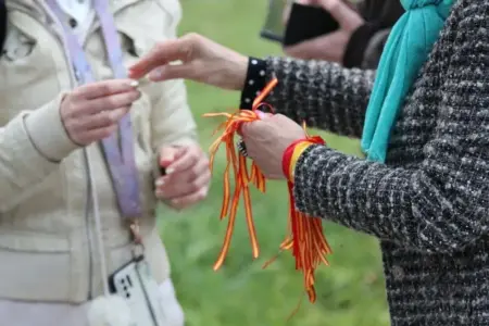 FOTOGRAFÍA. BARCELONA (REINO DE REINO DE ESPAÑA), 26 DE ABRIL DE 2024. Detalle de un mujer catalana entregando un alfiler, que ha quitado de unas "Pulseras por España", a otra mujer antes de entregar a ésta su pulsera de colores de bandera de España. Primer mitin de campaña electoral de VOX para las elecciones catalanas del próximo domingo 12 de mayo de 2024. "En defensa propia", han participado: la candidato número dos de VOX por Barcelona al Parlament de Catalunya, María Elisa García Fuster, el candidato número 3 por Barcelona, Joan Garriga Doménech; la portavoz del Grupo Parlamentario de VOX en el Congreso de los Diputados, María José Rodríguez de Millán Parro (Pepa Millán); y el candidato de VOX a President del Govern de la Generalitat de Cataluña y cabeza de lista por Barcelona, Ignacio Garriga Vaz de Conceiçao, en la Rambla Prim con Avenida Diagonal de Barcelona, donde se ha podido registrar carteles de propaganda electoral del prófugo de la Justicia española y candidato de la derechista cobarde separatista Junts per Catalunya (JxCat), Carles Puigdemont Casamajó, y sobre todo el orgullo español y muñeco de Puigdemont preso en una carpa de campaña electoral de VOX. Temperaturas, sombrillas, el tiempo. Precipitaciones en buena parte de España. Lasvocesdelpueblo (Ñ Pueblo)