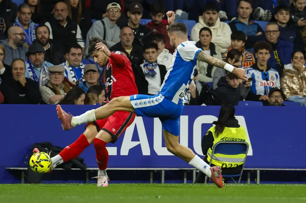 FOTOGRAFÍA. CORNELLÁ DE LLOBREGAT (BARCELONA) CATALUÑA (REINO DE ESPAÑA, 07 DE DICIEMBRE DE 2025. El lateral del Rayo Andrei Ratiu (i) juega un balón ante Roberto Fernández, del Espanyol, durante el partido de LaLiga de fútbol que RCD Espayol y Rayo Vallecano disputan este domingo en el RCDE Stadium, en Barcelona. Efe