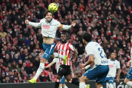 FOTOGRAFÍA. BILBAO (LAS VASCONGADAS) REINO DE ESPAÑA, 22 DE DICIEMBRE DE 2025. El defensa uruguayo del Espanyol Leandro Cabrera (i) despeja un balón de cabeza durante el partido de la jornada 17 de LaLiga que Athletic Club de Bilbao y RCD Espanyol disputaron en San Mamés. Efe