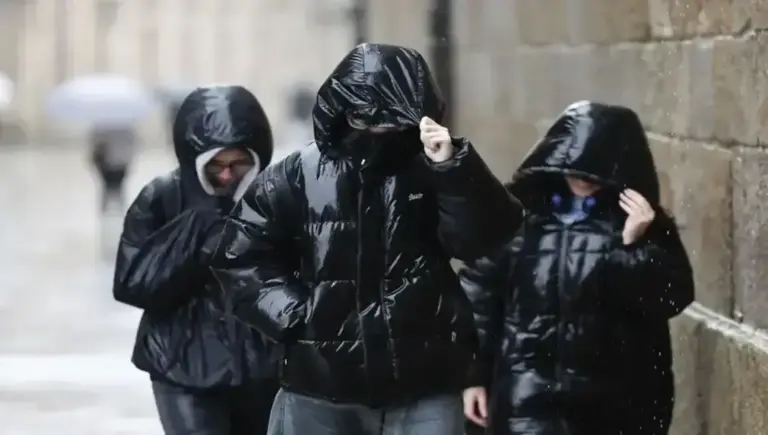 FOTOGRAFÍA. SANTIAGO DE COMPOSTELA (GALICIA) ESPAÑA, 21 DE ENERO DE 2026. Sábado de chubascos y descenso generalizado de temperaturas. Varias chicas caminan bajo la lluvia en Santiago de Compostela este miércoles. Efe