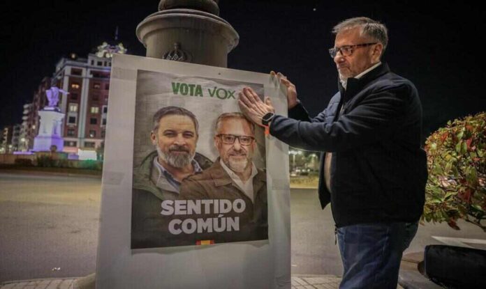 FOTOGRAFÍA. LEÓN (CASTILLA Y LEÓN) ESPAÑA, 26 DE FEBRERO DE 2026. 12 ejes y 509 soluciones del programa electoral de VOX en CyL. Elecciones Castilla y león 15M. El candidato de VOX a la Presidencia de la Junta de Castilla y León, Carlos Pollán Fernández (d); aparece e la derecha del cartel oficial de calle Bambú 12 de Madrid, junto a al mandatario de VOX España y presidente de Patriots of Europe, Santiago Abascal Conde (en la izquierda), bajo firma "Sentido Común". Esta noche, el candidato Pollán ha iniciado esta noche la campaña electoral para las elecciones del próximo 15 de marzo con una pegada de carteles en la Plaza de Guzmán el Bueno, junto a Laura Dorreis y Miguel Suárez, números dos y tres respectivamente en la lista por León a las Cortes de CyL Lasvocesdelpueblo (Ñ Pueblo)