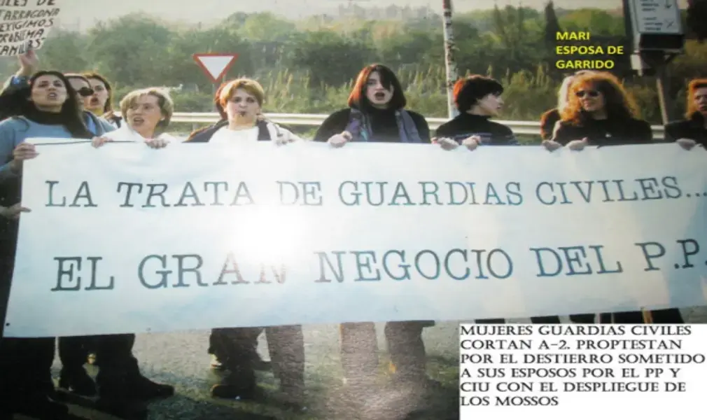 FOTOGRAFÍA. CATALUÑA (ESPAÑA), AÑO 1996. Detalle de una de las imágenes históricas y sin precedentes que muestra a varios de las 3.000 familias de los guardias civiles durante una protesta contra la traición del socialismo azul y corrupto de España Partido Popular (PP) a la Guardia Civil. "La trata de los guardias civiles; el gran negocia del PP". Los guardias civiles y sus familias "cortan autopistas" en Cataluña por "el destierro" al que están siendo sometidos por parte de las formaciones políticas "corruptas: partido Popular (PP) y Convergencia i Unió (CiU)", denuncian en la protesta. Florencio Garrido Vela/Lasvocesdelpueblo (Ñ Pueblo)