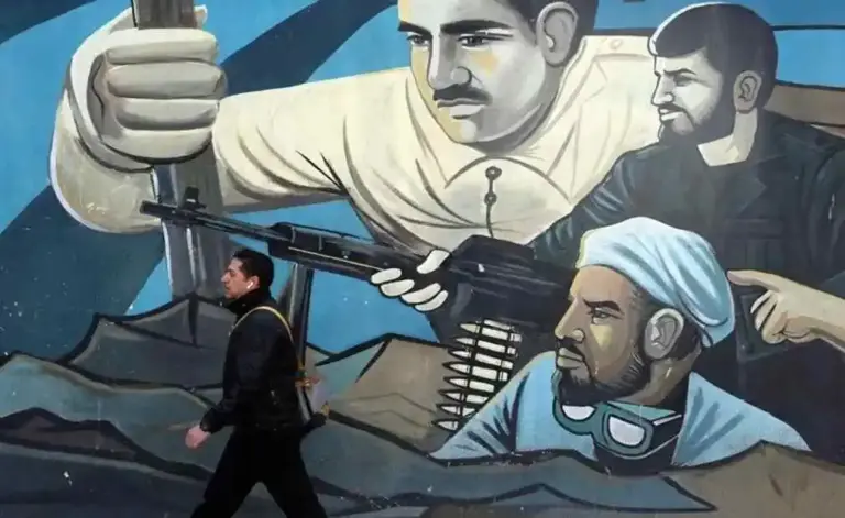 FOTOGRAFÍA. TEHERÁN (PERSIA), 25 DE FEBRERO DE 2026. Un hombre iraní pasa junto a un mural de milicias de los Ayatolás ISIS, declarados por la Unión Europea y Estados Unidos de América "organización terrorista" en Teherán, capital de Persia, en la actualidad Republica Islámica de Irán. Efe