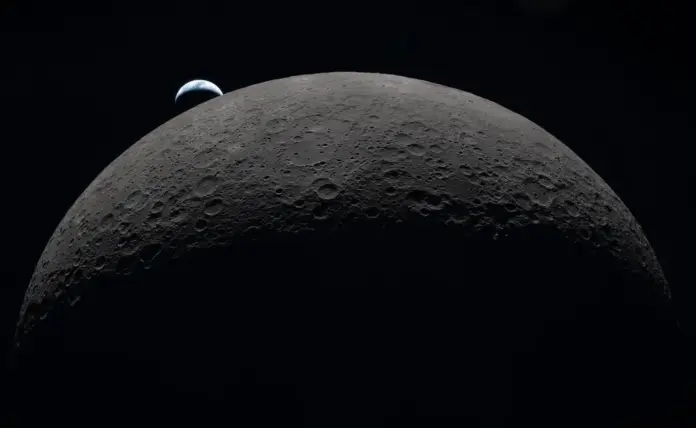 FOTOGRAFÍA. ESPACIO (MÁS ALLÁ DE LA ATMÓSFERA TERRESTRE), 06 DE ABRIL DE 2026. Artemis II comienza el regreso a 36.286 millas de la Luna y 236.022 de la Tierra. Puesta de sol capturada a través de la ventana de la nave espacial Orion a las 18:41 EDT, el 6 de abril de 2026, durante el sobrevuelo de la Luna por la tripulación de Artemis II. Una Tierra de un azul tenue con brillantes nubes blancas se pone tras la superficie lunar caracterizada. La parte oscura de la Tierra está experimentando la noche. En el lado diurno de la Tierra, se observan nubes arremolinadas sobre la región de Australia y Oceanía. En primer plano, el cráter Ohm tiene bordes escalonados y un fondo plano interrumpido por picos centrales. Los picos centrales se forman en cráteres complejos cuando la superficie lunar, licuada por el impacto, salpica hacia arriba durante la formación del cráter. Nasa/Lasvocesdelpueblo (Ñ Pueblo)
