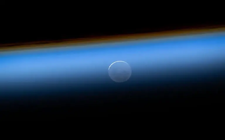FOTOGRAFÍA. ESPACIO (MÁS ALLÁ DE LA ATMÓSFERA TERRESTRE), 07 DE ABRIL DE 2026. Comunicación entre Estación Espacial y Artemis II: hito histórico para la NASA. En esta fotografía tomada desde la Estación Espacial Internacional el 27 de mayo de 2025, se observa la Luna Nueva aparentemente debajo de la atmósfera terrestre durante una puesta de sol orbital. Nasa/Lasvocesdelpueblo (Ñ Pueblo)