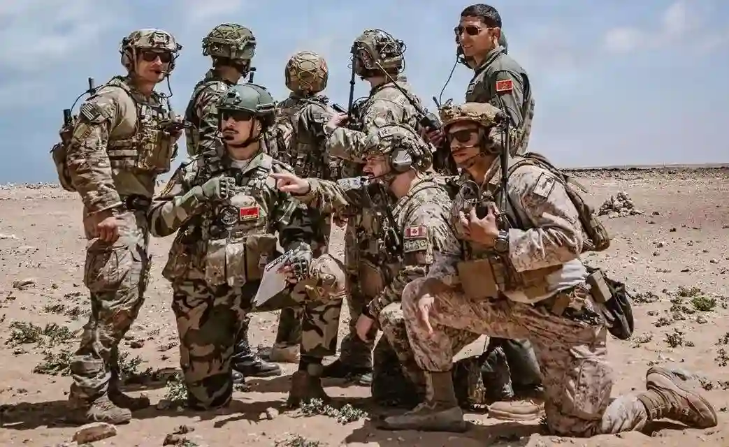 FOTOGRAFÍA. TAN-TAN (MARRUECOS), 23 DE ABRIL DE 2026. Militares estadounidenses y aliados posan para una foto mientras aviones B-52 Stratofortress de la Fuerza Aérea de EEUU y F-16 Fighting Falcon de la Fuerza Aérea Marroquí sobrevuelan una zona de entrenamiento durante el ejercicio African Lion 26 en Tan-Tan, Marruecos, el 23 de abril de 2026. El entrenamiento de integración de bombarderos permite a las fuerzas estadounidenses proyectar una capacidad aérea de combate creíble, operando junto a aliados y socios multilaterales en África, Europa y el resto del mundo. El Sargento del Ejército de EEUU, Christopher Sanchez/Lasvocesdelpueblo (Ñ Pueblo)