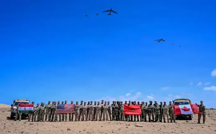 FOTOGRAFÍA. TAN-TAN (MARRUECOS), 23 DE ABRIL DE 2026. Aviones B-52H Stratofortress de la Fuerza Aérea de EEUU y cazas F-16 Fighting Falcon de la Fuerza Aérea Marroquí sobrevuelan una zona de entrenamiento mientras militares de EE. UU., Marruecos, Canadá y Hungría posan para una foto durante el ejercicio African Lion 26 en Tan-Tan, Marruecos, el 23 de abril de 2026. El suboficial de segunda clase de la Armada, Samuel Wagner/Lasvocesdelpueblo (Ñ Pueblo)