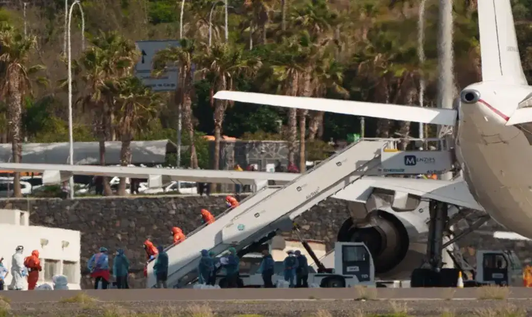 FOTOGRAFÍA. GRANADILLA DE ABONA (TENERIFE) ISLAS CANARIAS (ESPAÑA), 10 DE MAYO DE 2026. En la imagen, miembros de la Unidad Militar de Emergencias con trajes de protección en la escalerilla de la aeronave este domingo en Granadilla de Abona (Tenerife) Islas Canarias España durante la evacuación de pasajeros a bordo del crucero MV Hondius. Efe