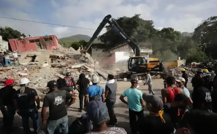 FOTOGRAFÍA. LA GUAIRA (VENEZUELA), 27 DE JUNIO DE 2026. EEUU y España buscan supervivientes o fallecidos en Venezuela. Vista general este 26 de junio de un grupo de personas al observar las labores de remoción de escombros de una retroexcavadora, dos días después del par de terremotos que azotaron el centro norte de Venezuela, en el estado La Guaira. Efe