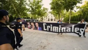 FOTOGRAFÍA. MADRID (ESPAÑA), 17 DE JUNIO DE 2026. Zapatero sostiene ante el juez que únicamente hizo trabajos de consultoría. Protesta de personas en el entorno de la Audiencia Nacional contra la corrupción con un cartel que señala a los "criminales". El expresidente del Gobierno de España y exsecretario general del Partido Socialista (PSOE), José Luis Rodríguez Zapatero, tiene que declarar este miércoles como investigado por organización criminal, tráfico de influencias y falsedad en la causa sobre el préstamo a la compañía aérea Plus Ultra. Efe