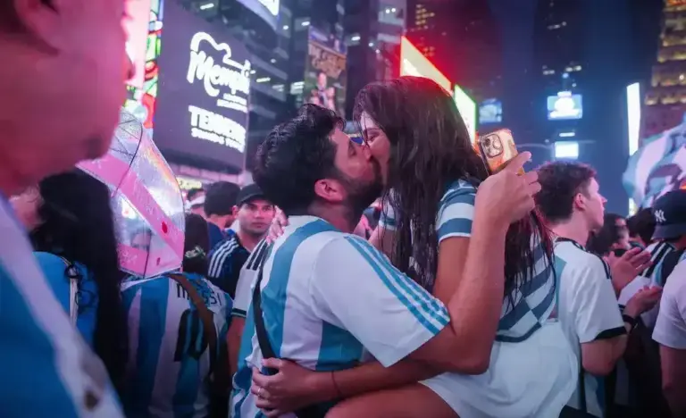 FOTOGRAFÍA. NUEVA YORK (ESTADOS UNIDOS DE AMÉRICA, EEUU), 18 DE JULIO DE 2026. España vs Argentina - Argentinos: El que no salte es español. Una pareja se besa mientras miles de aficionados argentinos se concentran en Times Square en vísperas de la final del Mundial 2026 entre la selección de su país y la de España, que se disputa este domingo. Efe
