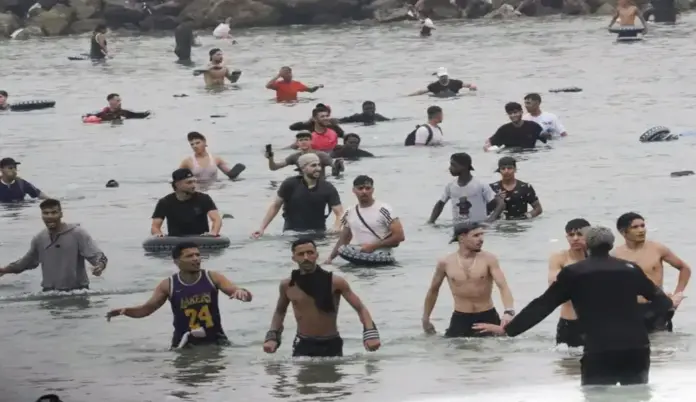 Invasión de Ceuta, Ceuta, marroquíes, VOX ordena a sus Gobiernos suspender ayudas a ONG migracionistas (3) FOTOGRAFÍA. CIUDAD AUTÓNOMA DE CEUTA (ESPAÑA), 31 DE JULIO DE 2026. Invasión marroquí de ceuta (España). Un grupo de invasores inmigrantes ilegales irrumpe masivamente en la playa junto al paso fronterizo del Tarajal (Castillejos) Marruecos y Ceuta (España) este viernes, 31 de julio de 2026, tercer día de la invasión marroquí de Ceuta, más de 50.000 invasores, según datos de fuentes gubernamentales españolas este viernes en rueda de prensa cuando se siga registrando nuevos asaltos. El Gobierno de España dice que al menos la mitad de los 50.000 invasores ya ha retornado voluntariamente a Castillejos (Marruecos) al tiempo que anuncia reforma de la Ley de Extranjería, sin contar con los votos suficientes para lograr su aprobación, para poder hacer las repatriación masivas de ilegales; el mismo Ejecutivo del socialista y migracionista Pedro Sánchez Pérez-Castejón que tiene en la actualidad un proceso de regularización masiva de más de 1.000.000 de ilegales en el país desde 2021. Efe