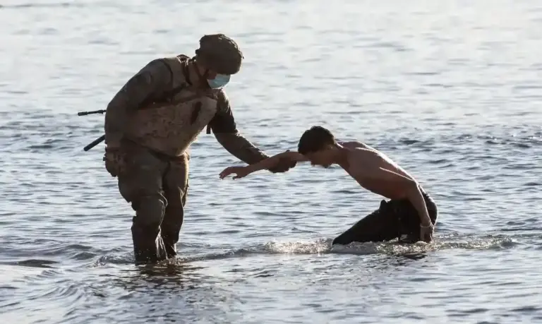 FOTOGRAFÍA. CEUTA (ESPAÑA), 29 DE JULIO DE 2026. Llega masiva a nado de ilegales marroquíes a Ceuta. Un soldado del ejército español ayuda a un inmigrante ilegal magrebí a su llegada a nado a la playa de El Tarajal en Ceuta, España. Efe