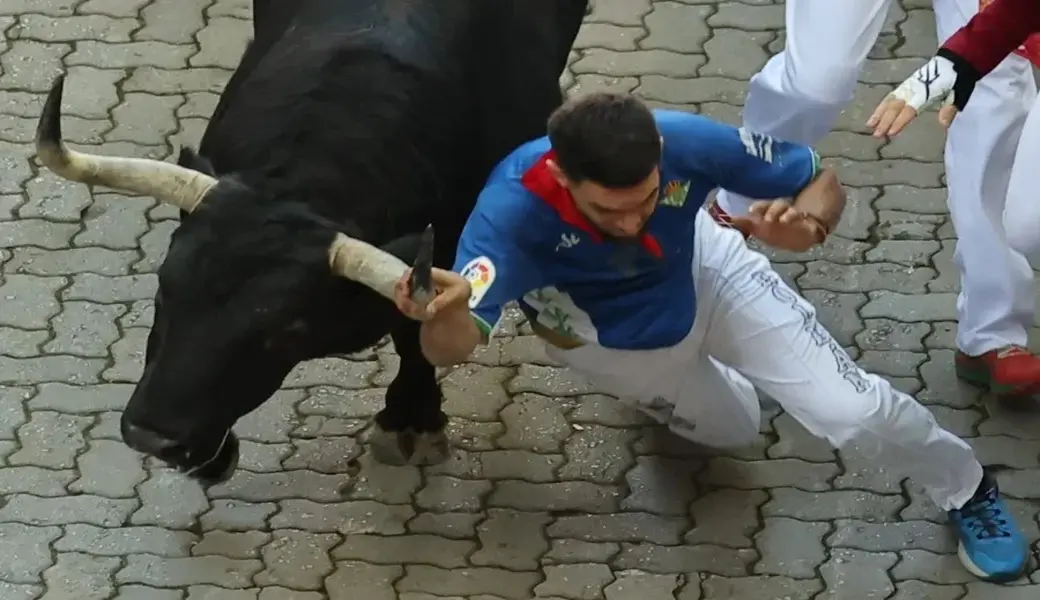 FOTOGRAFÍA. PAMPLONA (NAVARRA) ESPAÑA, 07 DE JULIO DE 2026. Carrera rápida y emocionante sin heridos por asta de Sanfermines 2026. Un mozo cae al paso de uno los toros de la ganadería gaditana de Fuente Ymbro. Efe