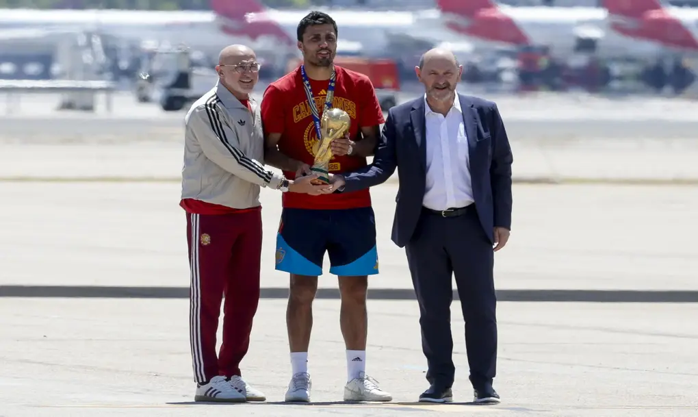 FOTOGRAFÍA. MADRID (ESPAÑA), 20 DE JULIO DE 2026. La selección campeona del mundo ante Argentina llega a Madrid. El capitán de la selección española de fútbol, Rodri (c), que lleva el trofeo de la Copa del Mundo, acompañado del seleccionador nacional, Luis de la Fuente Castillo (i), y el presidente de la RFEF, Rafael Louzán, a su llegada al aeropuerto de Madrid Barajas después de proclamarse anoche campeona del Mundial en Estados Unidos tras vencer a Argentina en la final. Efe