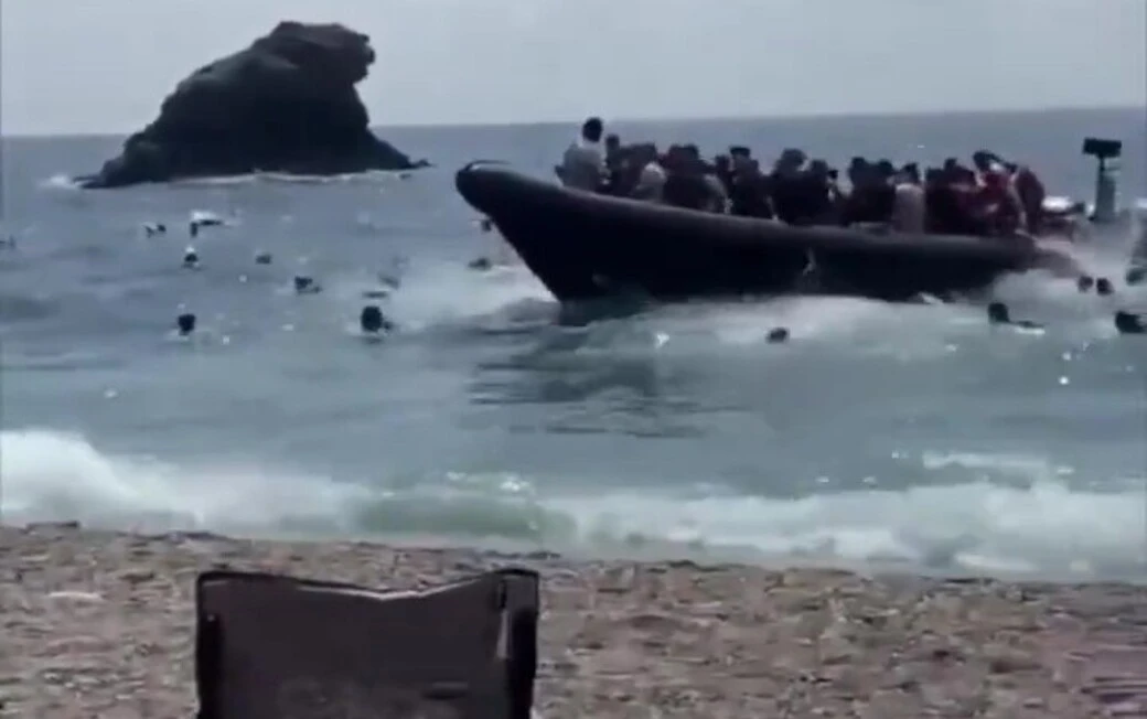 FOTOGRAFÍA. CARTAGENA (REGIÓN DE MURCIA) ESPAÑA, 21 DE AGOSTO DE 2026. Una lanchas rápidas (patera) con varias decenas de inmigrantes ilegales magrebíes, desembarca en la cala del Barco de Cartagena ante varios turistas y vecinos de Murcia, entre ellos muchos en el miedo que abandonaron el lugar corriendo. Los ilegales magrebíes desaparecieron por la ciudad, respondiendo a la llamada del Gobierno mugracionsista de España en coalición del Partido Socialista (PSOE) y Movimiento Sumar, con Pedro Sánchez Pérez-Castejón al frente, de una regularización masiva de los indocumentados en el país. la llamada de fronteras abiertas de España del PSOE y Sumar, apoyada por Podemos, llegó correctamente a los destinarios que ahora están llegando en masas por todas partes. Captura vídeo de testigos/Lasvocesdelpueblo (Ñ Pueblo)