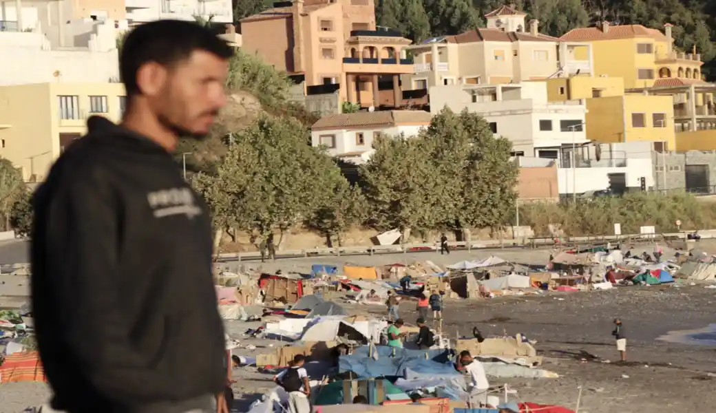 FOTOGRAFÍA. CEUTA (ESPAÑA), 27 DE AGOSTO DE 2026. Numerosos inmigrantes ilegales de la invasión de Ceuta del pasado final de mes de julio de 2026 continúan asentados en la playa de El Trampolín de Ceuta, España, mientras desde el Gobierno de España de Pedro Sánchez Pérez-Castejón la solución no pasa por las deportaciones a su país de origen ubicado a tan solo 500 metros de la misma playa sino mirar por otro lado e instrumentalizar la inmigración ilegal pese al calvario de los compatriotas ceutíes cuya casas se han convertido en sus propias cárceles desde hace casi un mes. Efe