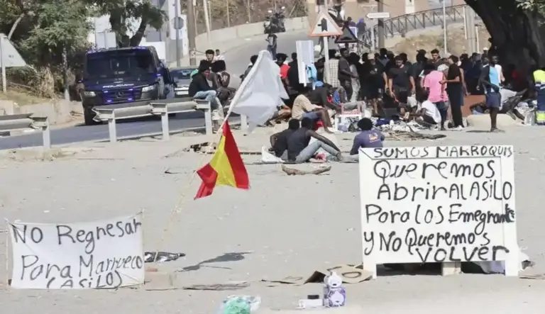 FOTOGRAFÍA. CEUTA (ESPAÑA), 19 DE AGOSTO DE 2026. En la imagen, centenares de los invasores inmigrantes ilegales marroquíes del asalto masivo a la frontera marítima y terrestre de España en Ceuta, acampados en la Playa del Trampolín de la Ciudad Autónoma de Ceuta, exigiendo ser acogido por España y ser traslados a la Península en hoteles con pensión y papeles. Y es que varios de los asaltantes amenazan con que han iniciado una huelga de hambre para obligar al Gobierno de Pedro Sánchez Pérez-Castejón a atender sus exigencias de acogida y regularización masiva. Efe