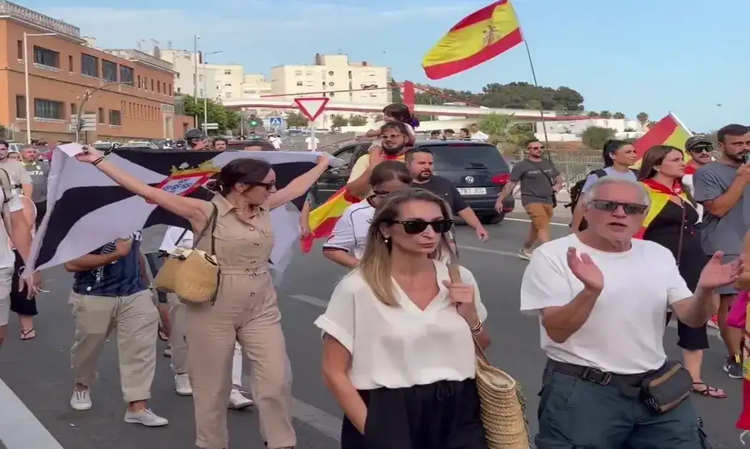 FOTOGRAFÍA. CEUTA (ESPAÑA), 25 DE AGOSTO DE 2026. Ceuta protesta contra acogida de inmigrantes: invasores deportación; invasores expulsión. Varios cientos de vecinos de Ceuta han trasladado este martes hasta la plaza de los Reyes, frente a la Delegación del Gobierno, la protesta contra el posible alojamiento de inmigrantes ilegales -"invasores", apuntan los manifestantes visiblemente hartos y muy desamparados ante la inacción completa de las autoridades locales y nacionales- en distintos puntos de la ciudad, después de que una concentración iniciada en la zona del Fischer se haya convertido en una movilización ciudadana. Lasvocesdelpueblo (Ñ Pueblo)