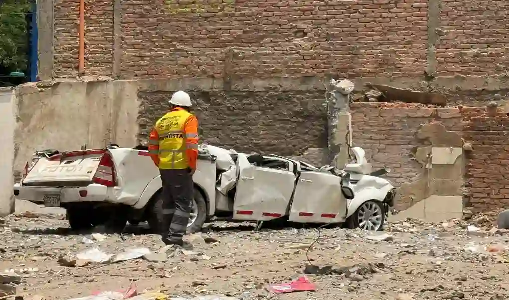 FOTOGRAFÍA. CALI (COLOMBIA), 15 DE AGOSTO DE 2026. Colombia: La pareja Jairo y Blanca y dos de sus hijas trillizas murieron sepultados bajo los escombros. Un hombre observa un carro destruido en el barrio Cuarto de Legua - Guadalupe, barriada del sur-occidente de Cali, en la Comuna 19, sector residencial tradicional situado cerca de la Carrera 56 y la Avenida Guadalupe, donde vivían las trillizas Saavedra. Efe