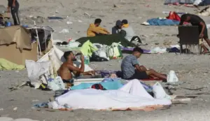 FOTOGRAFÍA. CEUTA (ESPAÑA), 22 DE AGOSTO DE 2026. El Gobierno urge el envío solidario a Ceuta de vacunas triple vírica, varicela, poliomielitis, tétanos y difteria. Varios inmigrantes ilegales marroquíes permanecen acampados este sábado en la playa El Trampolín de Ceuta. Varios ilegales de la invasión marroquí de la Ciudad Autónoma española de Ceuta regresaron a pesar de que agentes del Cuerpo Nacional de la Policía española volvieron a desalojar ayer, viernes 21 de agosto de 2026, a los más de mil invasores ilegales que se encontraban en esta misma playa ceutí El Trampolín, después de también de regresar allí tras el primer traslado de al menos 1.700 ilegales en centros habilitado por el Gobierno globalista, migracionista y socialcomunista de España de Pedro Sánchez Pérez-Castejón. Efe