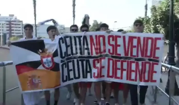 Jugadores del Ceuta y Las Palmas lucen camisetas Ceuta no se vende. Ceuta se defiende, Ceuta - Las Palmas Pedro Sánchez hijo de puta, Ceuta no se vende, Ceuta se defiende (2) FOTOGRAFÍA. CEUTA (ESPAÑA), 22 DE AGOSTO DE 2026. Una pancarta con el mensaje "Ceuta no se vende. Ceuta se defiende" ha recorrido las calles de la ciudad hasta llegar al estadio municipal Alfonso Murube, donde los futbolistas del Ceuta y de Las Palmas la han sostenido antes de enfrentarse en partido de la Liga Hypermotion, a modo de protesta ante la situación que vive la ciudad por la entrada masiva de más de 70.000 inmigrantes desde Marruecos el 30 de julio de 2026. Captura vídeo Efe/Lasvocesdelpueblo (Ñ Pueblo)