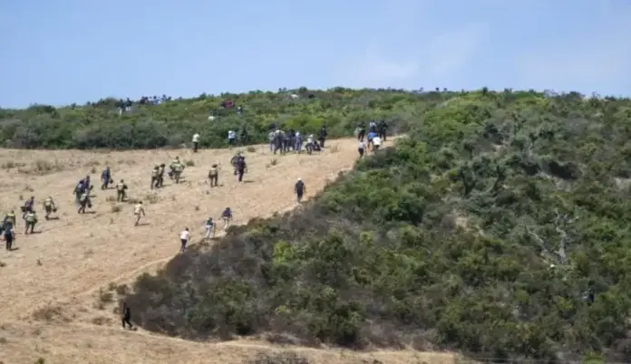 FOTOGRAFÍA. CASTILLEJOS (MARRUECOS), 15 DE AGOSTO DE 2026. Marruecos carga contra los inmigrantes en la frontera con España. Varios grupos de inmigrantes norteafricanos islamistas, en su mayoría de Sudán, y subsaharianos, también en su mayoría islamistas, se congregan cerca de Castillejos (Marruecos), mientras intentan asaltar la frontera española de Ceuta este sábado, 15 de agosto de 2026. Fuentes de seguridad marroquíes indicaron que los intentos de entrada tuvieron lugar en una zona montañosa en las afueras de Castillejos, al suroeste de Ceuta. Efe
