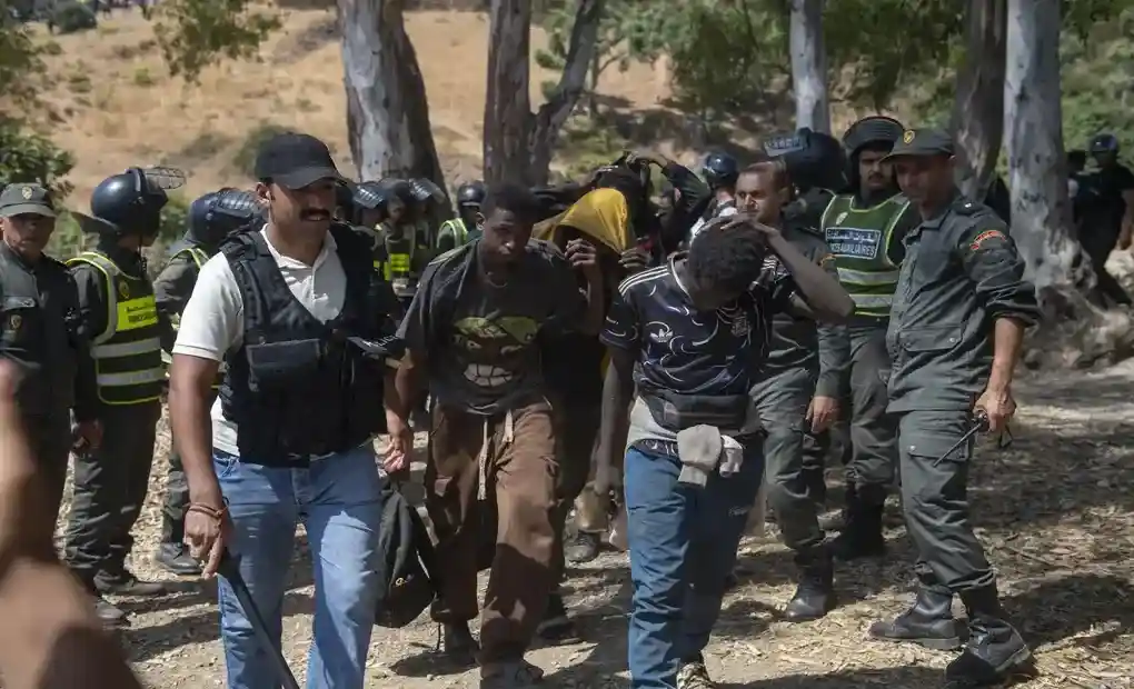 FOTOGRAFÍA. CASTILLEJOS (MARRUECOS), 15 DE AGOSTO DE 2026. Marruecos carga contra los inmigrantes en la frontera con España. Varios grupos de inmigrantes norteafricanos islamistas, en su mayoría de Sudán, y subsaharianos, también en su mayoría islamistas, se congregan cerca de Castillejos (Marruecos), mientras intentan asaltar la frontera española de Ceuta este sábado, 15 de agosto de 2026. Fuentes de seguridad marroquíes indicaron que los intentos de entrada tuvieron lugar en una zona montañosa en las afueras de Castillejos, al suroeste de Ceuta.Efe