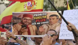 FOTOGRAFÍA. CEUTA (ESPAÑA), 28 DE AGOSTO DE 2026. Nueva movilización de compatriotas ceutíes: Invasores expulsión. Un cartel de compatriotas ceutíes muestra una polémica conversación entre el monarca marroquí Sidi Mohamed ben Hasán ben Mohamed ben Yusef Alaui (Mohamed VI) (i); y el presidente del Gobierno migracionista y globalista de España por el Partido Socialista (PSOE), Pedro Sánchez Pérez-Castejón (d); en la que el monarca le exige a sánchez más recursos económico a cambio de su silencio sobre presuntos documentos de los presuntos espías marroquíes e israelíes en su poder que podrían mandar a Sánchez entre rejas si salieran a luz: "Pedrito, suelta más 'Flous (فلوس)'. Que me chivo". Cientos de personas han salido este viernes a las calles de Ceuta en una nueva movilización para expresar su malestar por la situación que atraviesa la ciudad autónoma desde la entrada masiva de miles de inmigrantes registrada el pasado final de mes de julio de 2026. Efe
