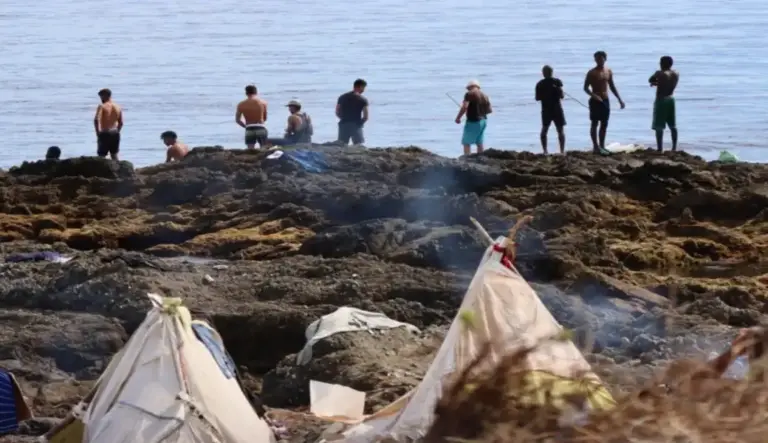 FOTOGRAFÍA. CEUTA (ESPAÑA), 29 DE AGOSTO DE 2026. Miles de inmigrantes ilegales de la invasión marroquí de Ceuta ocupan ilegalmente la playa de El Trampolín de Ceuta hasta la fecha de este sábado, 29 de agosto de 2026, lugar que el Gobierno de España del migracionista y globalista Pedro Sánchez Pérez-Castejón (PSOE) afirma que desalojó. Los invasores rechazan los centros de acogida del Gobierno de Sánchez y regresan cada día en las playas de la ciudad autónoma española de Ceuta. Efe