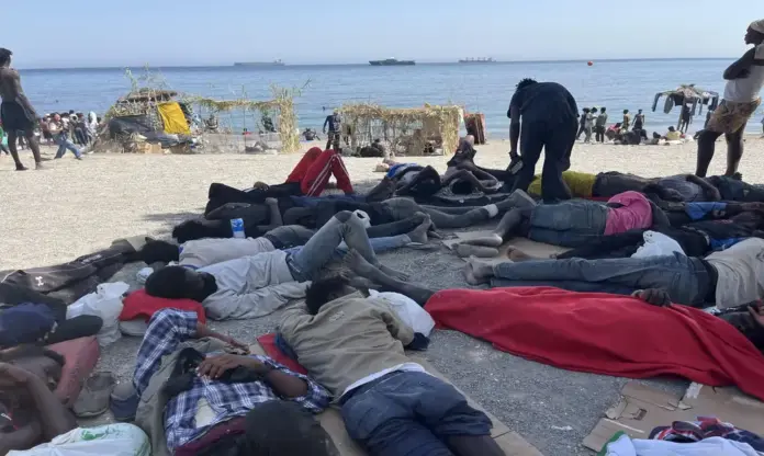 FOTOGRAFÍA. CEUTA (ESPAÑA), 13 DE AGOSTO DE 2026. Ceuta vive fracturada en dos realidades opuestas tras la entrada masiva de inmigrantes  ilegales marroquíes. En la imagen, numerosos inmigrantes permanecen en la playa del Trampolín en la ciudad autónoma de Ceuta, España. Efe