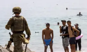 FOTOGRAFÍA. CIUDAD AUTÓNOMA DE CEUTA (ESPAÑA), 31 DE JULIO DE 2026. El Ejército, la Policía y Guardia Civil desplegados en Ceuta el tiempo que sea necesario. El Ejército español desplegado en la frontera del Tarajal (Castillejos) con Ceuta (España) ante la atenta mirada de los inmigrantes ilegales marroquíes este viernes, 31 de julio de 2026, tercer día de la invasión marroquí de Ceuta, más de 50.000 invasores, según datos de fuentes gubernamentales españolas este viernes en rueda de prensa cuando se siga registrando nuevos asaltos. El Gobierno de España dice que al menos la mitad de los 50.000 invasores ya ha retornado voluntariamente a Castillejos (Marruecos) al tiempo que anuncia reforma de la Ley de Extranjería, sin contar con los votos suficientes para lograr su aprobación, para poder hacer las repatriación masivas de ilegales; el mismo Ejecutivo del socialista y migracionista Pedro Sánchez Pérez-Castejón que tiene en la actualidad un proceso de regularización masiva de más de 1.000.000 de ilegales en el país desde 2021. Efe